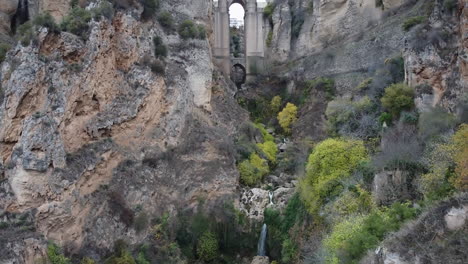 Tilt-up-from-bottom-of-gorge-to-Puente-Nuevo-bridge-in-Ronda,-Spain