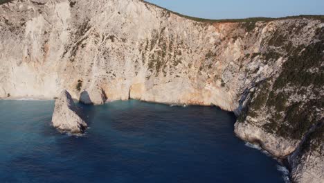Hill-island-cliff-with-blue-sea-water-at-Lefkada,-Greece---aerial-drone-tracking-shot-in-sunny-weather