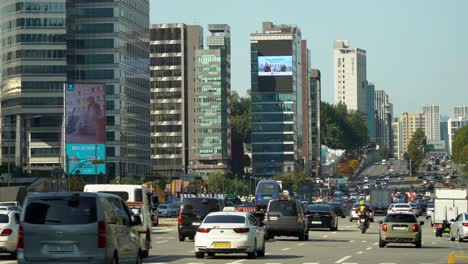 Car-Traffic-on-Yeongdong-daero-road-near-Coex-World-Trade-Center-Seoul-South-Korea,-Asem-tower,-Huge-outdoor-facade-Media-Display-Billboards-on-Building's-walls
