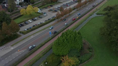 Fast-aerial-of-cars-driving-over-road-near-small-town