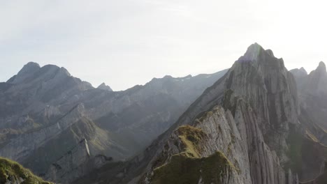 Vuelo-Aéreo-Hacia-Atrás-Que-Revela-A-Una-Persona-Que-Disfruta-De-La-Vista-De-Las-Montañas-Schäfler,-Appenzell,-Suiza