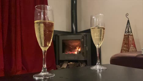 Static-video-of-two-glasses-of-champagne-in-a-romantic-room-with-a-fireplace-in-the-background