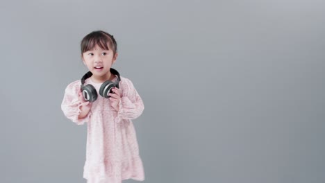 Süßes-Asiatisches-Mädchen-Mit-Kopfhörern-Genießt-Musik-Und-Tanz-Und-Dreht-Sich-Glücklich-Im-Studio-Um