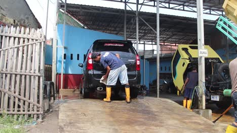 Worker-car-cleaning,-spraying-and-wiping,-clean-the-car-from-dirt,-at-his-workplace,-Batang,-14-July,-2021