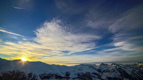 Luftaufnahme-Des-Sonnenuntergangs-über-Schneebedeckten-Bergen-Im-Zeitraffer
