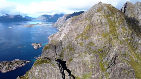 Flying-over-the-high-mountains-of-the-Lofoten-islands-in-northern-Norway-with-a-view-of-the-mountain-peaks-and-the-sea-with-its-many-small-islands-and-the-hiking-trails-up-the-mountain
