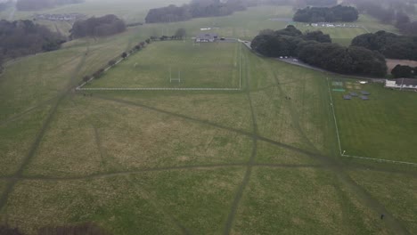Drone-shot-showing-a-sports-field-in-a-large-park-on-a-cloudy-day