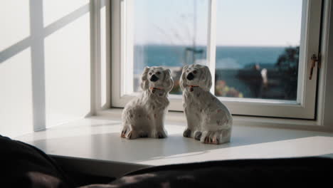 Fenster-In-Fanø-Dänemark-Mit-Zwei-Porzellanhunden,-Die-Hineinschauen