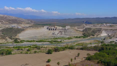 Drone-panoramic-landscape-view-of-the-Monte-Grande-dam-building-work-in-progress,-Barahona,-Dominican-Republic