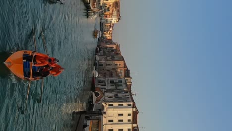 Team-of-four-oarsmen-training-rowing-standing-on-Venetian-traditional-boat-on-Venice-canal-in-Italy