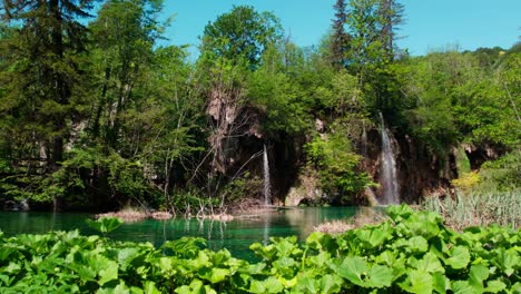 Niedriger-Blickwinkel-Auf-Kleine-Wasserfälle,-Die-In-Einer-Idyllischen-Grünen-Naturlandschaft-Mit-Türkisfarbenem-Wasser-Fließen