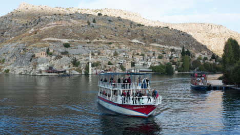 Turistas-En-Ferry-Dejando-El-Antiguo-Halfeti-Con-Mezquita-Hundida-En-Halfeti,-Turquía