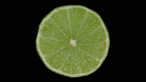 Slice-Of-Lime-Rotating-In-Black-Background