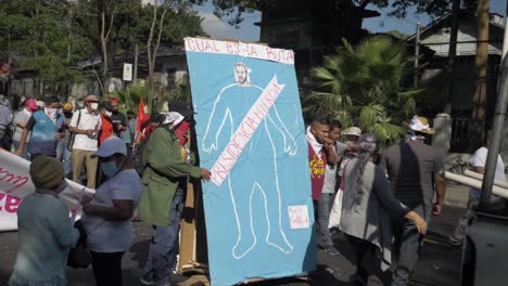 Los-Manifestantes-Llevan-Una-Pancarta-Con-Una-Representación-Ofensiva-Del-Actual-Presidente-Nayib-Bukele---Cámara-Lenta