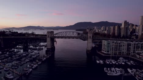 Drone-flying-over-Burrard-Bridge-at-sunset,-Vancouver-in-Canada