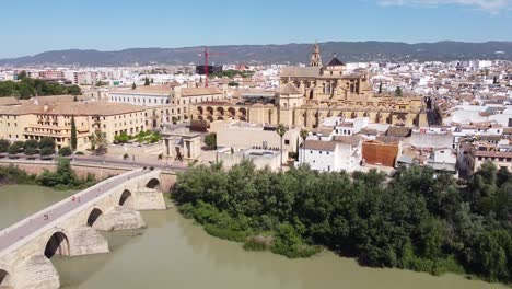 Cordoba,-Andalusia,-Spain---Aerial-Drone-View-of-the-Roman-Puente-Romano-Bridge,-Mezquita-Mosque-Cathedral-and-River-Guadalquivir