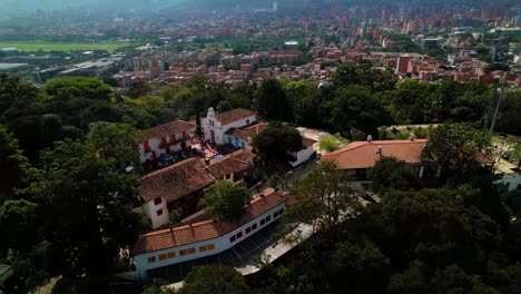 Large-residential-property-on-a-hill-in-Medellin-surrounded-by-tall-green-trees-on-a-sunny-day