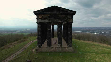 Aerial-zoom-out-cinematic-rotating-shot-of-Penshaw-Monument-at-North-East,-UK-in-a-cloudy-evening