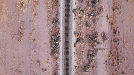 Drone-shot-looking-down-on-railroad-tracks-in-the-center-of-the-video-frame