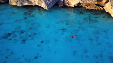 Aerial-view-of-a-person-snorkeling-on-the-shore-of-Cas-Abao-Beach,-Dutch-island-of-Curacao-in-the-Caribbean