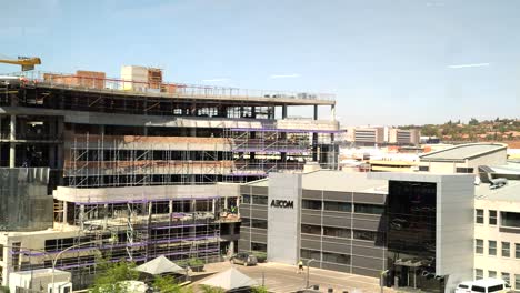 Entrance-to-AECOM-Head-Office,-the-building-towered-by-a-new-commercial-property-currently-being-developed-alongside-the-multinational-engineering-firm,-Midrand,-South-Africa