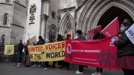 Gewerkschaftsmitglieder-Und-Unterstützer-Halten-Vor-Den-Königlichen-Gerichtshöfen-Ein-Gelbes-„United-Voices-Of-The-World“--Und-Ein-Rotes-„Independent-Worker-Of-Great-Britain“-Banner