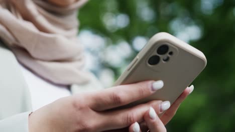 Nahaufnahme-Einer-Nicht-Wiederzuerkennenden-Frau-Mit-Hijab,-Die-Ihr-Telefon-Benutzt,-Und-Eines-Arabischen-Mädchens,-Das-Ein-Smartphone-Benutzt