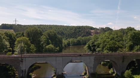 An-old-train-trestle-bridge-leading-over-the-Sieg-river-in-west-Germany-on-a-sunny-day