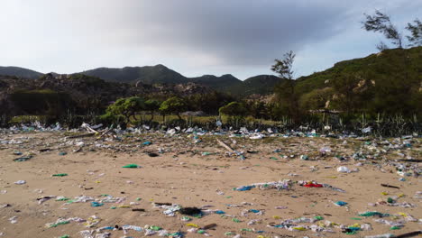 Drone-fly-above-sandy-tropical-polluted-beach-with-plastic-waste-chemicals-and-trash