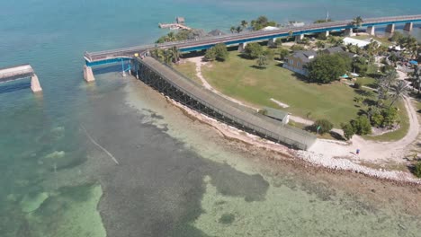 old-seven-mile-bridge-pigeon-key-rebuilt-tourism-vacation-tropical-destination-florida-clear-blue-water-ocean-gulf-aerial-drone-orbit