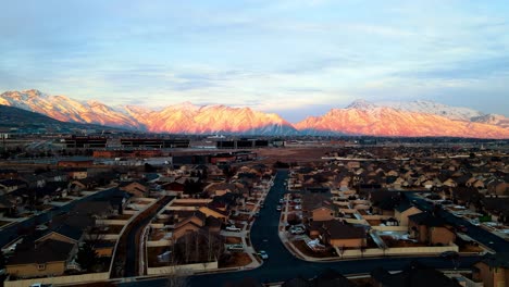 Silicon-Slopes-in-Lehi,-Utah-with-the-sunset-glowing-on-the-snowy-mountains---sliding-aerial-view