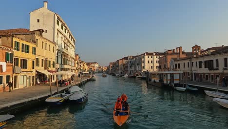 Team-Von-Ruderern,-Die-Das-Rudern-Auf-Einem-Traditionellen-Venezianischen-Boot-Auf-Dem-Kanal-Von-Venedig-Im-Bezirk-Cannaregio-In-Italien-Trainieren