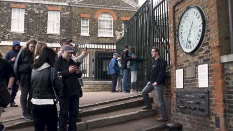 Visitors-Taking-Photo-Of-Wall-Clock-Outside-Beside-Gates-At-Royal-Observatory-Greenwich-On-7-May-2022