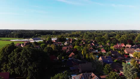 Eine-Drohnen-Luftaufnahme,-Die-Unter-Klarem-Blauen-Himmel-über-Ein-Schönes-Dorf-Fliegt