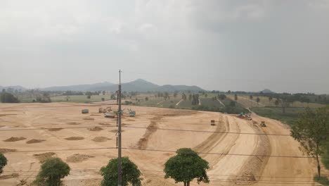Heavy-machinery-working-on-Construction-site,-Dirt-field-being-prepare-to-infrastructure,-Aerial-view