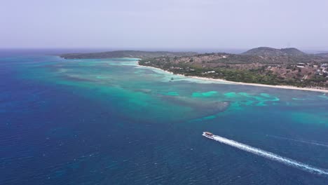 Ein-Touristenboot-Fährt-Im-Blauen-Meer-Am-Strand-Von-Playa-Ensenada-In-Der-Dominikanischen-Republik-Entlang