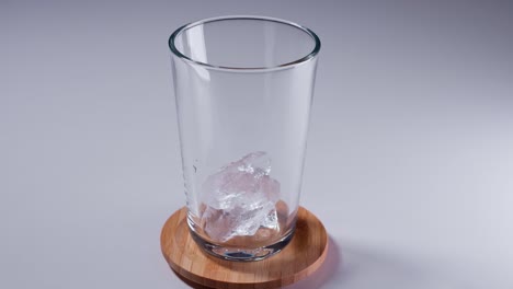 Geben-Sie-Zerstoßenes-Eis-In-Ein-Glas-Mit-Zerstoßenem-Eis-Auf-Einem-Tisch