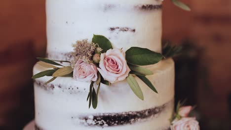 Close-Up-of-Layered-Wedding-Cake-with-White-Frosting-and-Pink-Rose-Decor-1080p-60fps