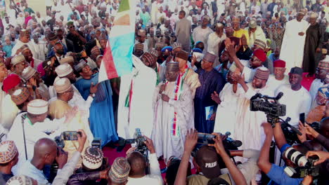 Political-election-candidates-wave-flags-and-speak-to-supporters-at-a-campaign-rally-in-Damaturu,-Nigeria