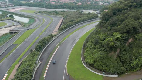 Aerial-view-ion-blue-lotus-sport-car-riding-over-the-race-track-in-china