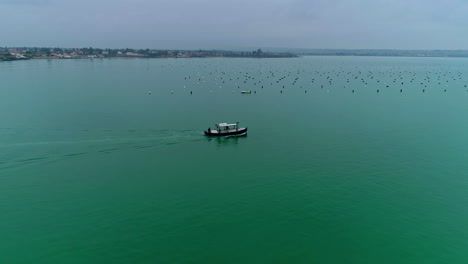 Drone-flight-over-local-boat-in-Italy-cruising-on-very-calm-Mediterranean-Sea