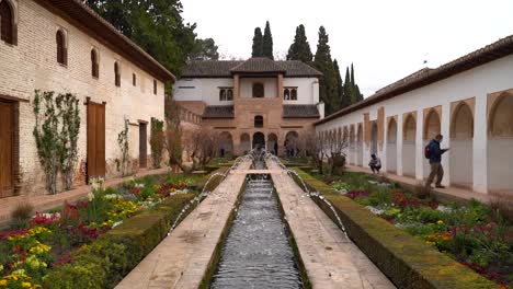 Few-people-walking-around-summer-gardens-of-Alhambra-in-Granada,-Spain