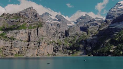 Low-level-drone-shot-of-the-Oeschinen-Lake-and-the-surrounding-mountains