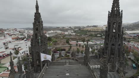 Fly-over-The-Church-of-San-Juan-Bautista-or-Arucas-Church,-beautiful-Neo-Gothic-style-towers,-Canary-Islands,-Spain
