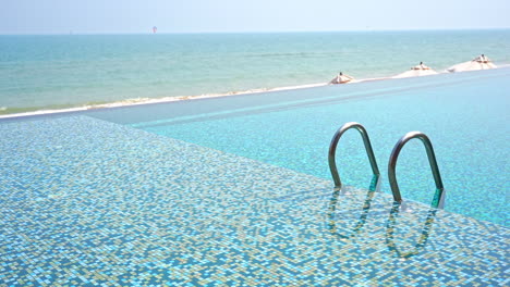 Empty-seafront-infinity-pool-entrance-with-metal-handrails