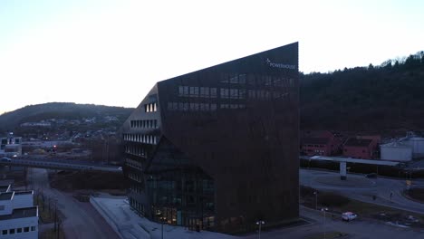 Powerhouse-Porsgrunn-facade-with-logo---Energy-plus-office-building-with-solar-roof---Ascending-evening-aerial-after-sunset