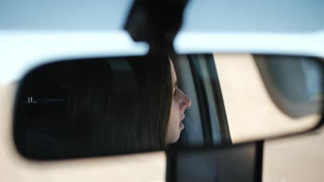 A-woman-looking-around-in-her-car-and-observing-the-surroundings