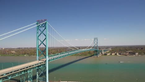 Ambassador-Bridge-connecting-Detroit,-Michigan-in-the-United-States-of-America-and-Windsor,-Ontario-in-Canada-drone-video-moving-up