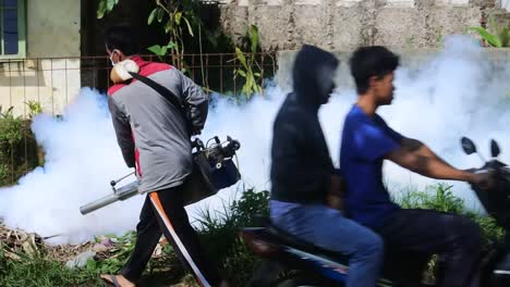 Professional-person-with-equipment-using-a-fogging-machine-with-insecticide-to-Eliminate-mosquitos-as-aedes-aegypti-in-an-outdoors-environment-in-Sukabumi,-West-Java,-Indonesia-on-May-8,-2022