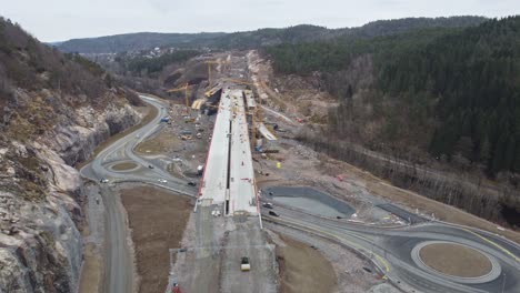 Company-nye-veier-AS-building-new-highway-E39-between-Mandal-and-Kristiansand-in-southern-Norway---Aerial-above-new-bridge-crossing-sogneelva-river-entering-bringeheia-in-Klepland-area